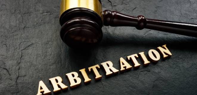Arbitration word from wooden letters and gavel in court.
