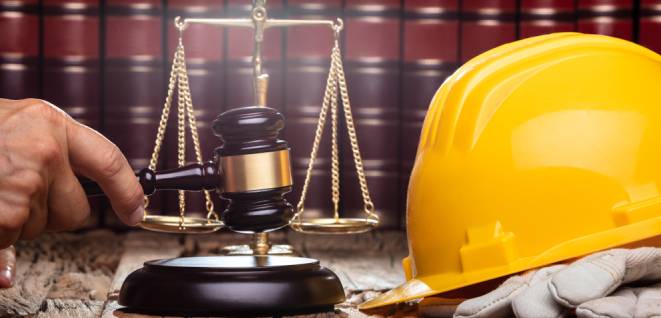 Judge Striking Gavel In Front Of Yellow Safety Helmet On The Wooden Table