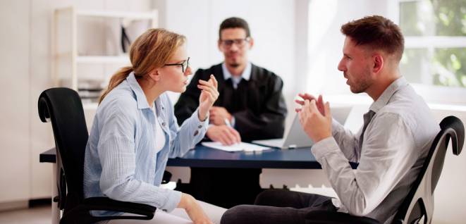 Young couple arguing in front of male judge, contemplating divorce