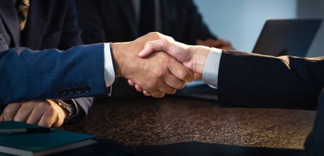 People shaking hands in a dark room