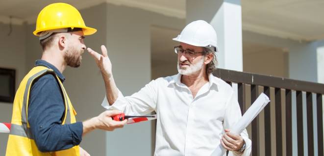 Senior caucasian white businessman complaining to building construction foreman about poor quality and late on process