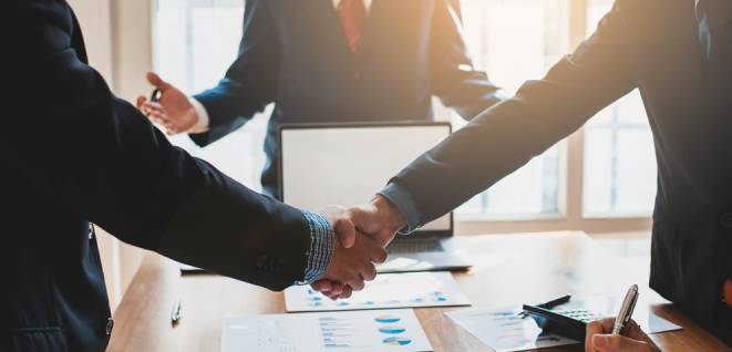 Business people shake hands with business partners at a meeting
